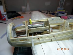 Fuel tank installed over bell crank assembly. Extra plywood scraps and lots of epoxy were used to hold fuel tank into position. Allowances needed to be made for fuel tank overflow vent and tube which can be seen exiting the fuselage to the left of the left lead out wire.