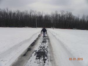 Hiking in from roadside parking with plane in hand and a happy smile in anticipation of winter flying.